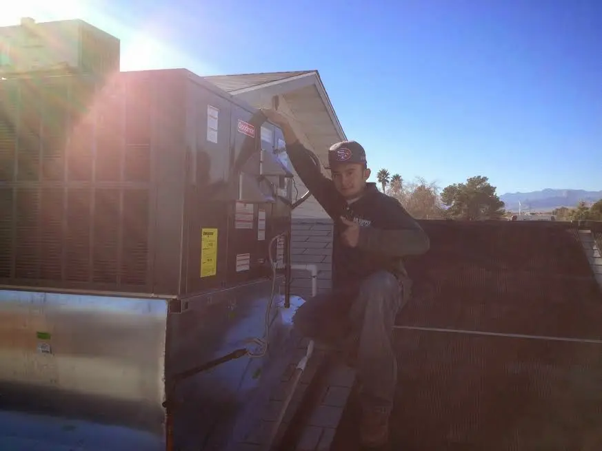 HVAC technician performing Boiler Repair on a rooftop unit in Heber